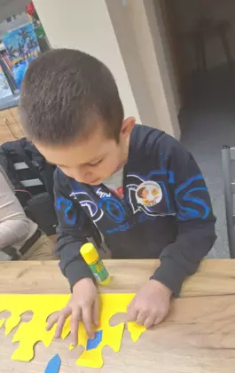 Chłopczyk wykleja koronę królewską.