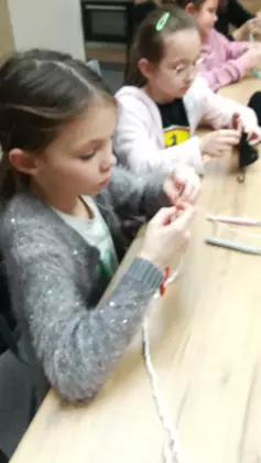 Uczestniczka warsztatów trzyma w rękach swoją pracę