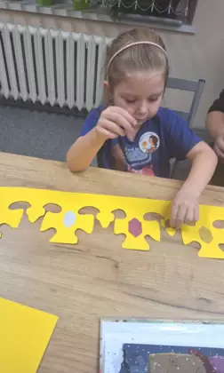 Dziewczynka wykleja koronę królewską.