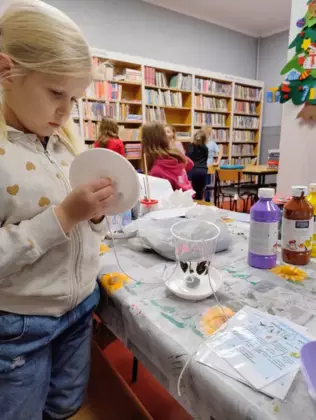 Dziewczynka wykonuje karmnik dla ptaków.