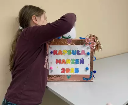 Dziewczynka wrzuca swoje postanowienia noworoczne do kapsuły marzeń.