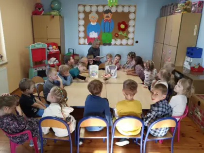 Pani bibliotekarka czyta dzieciom książeczki o babci i dziadku.