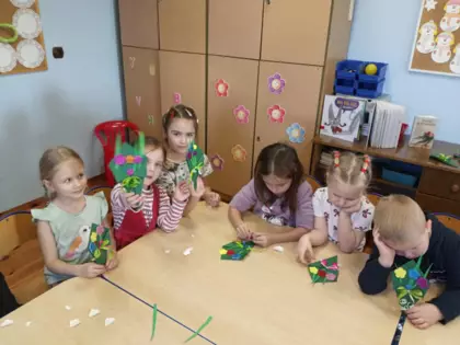 Przedszkolaki przy wspólnym stoliku wykonują prace dla babci i dziadka.