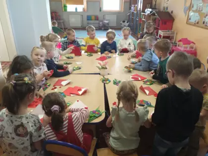Przedszkolaki przy wspólnym stoliku wykonują prace dla babci i dziadka.