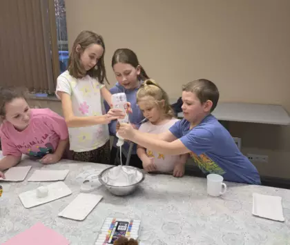 Dzieci z mąki i pianki do golenia ulepili bałwanka.