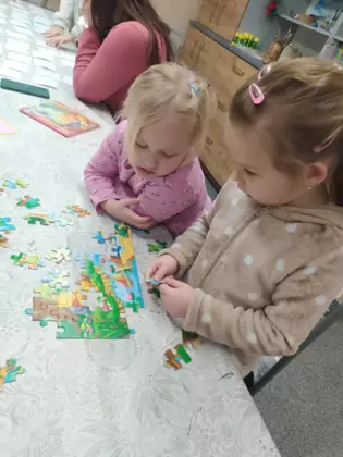 Dziewczynki układają puzzle.