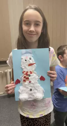 Dziewczynka z obrazkiem Olafa w ręce. Olaf wyklejony pianką.