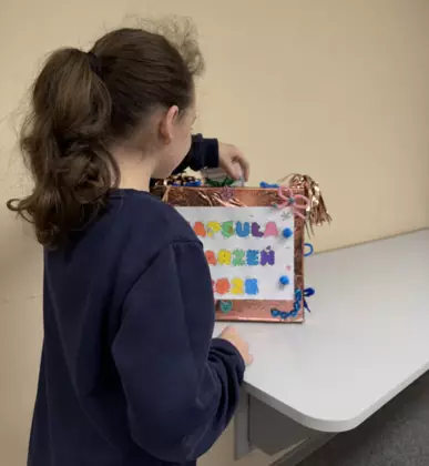 Dziewczynka wrzuca swoje postanowienia noworoczne do kapsuły marzeń.