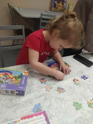 Dziewczynka układa puzzle.