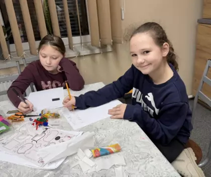 Dziewczyny piszą noworoczne postanowienia na kartce papieru.