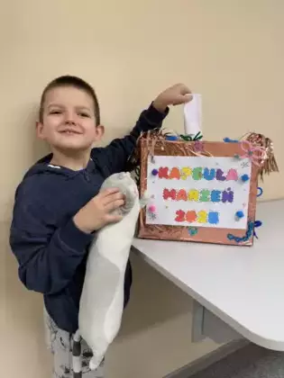 Chłopczyk wrzuca swoje postanowienia noworoczne do kapsuły marzeń.