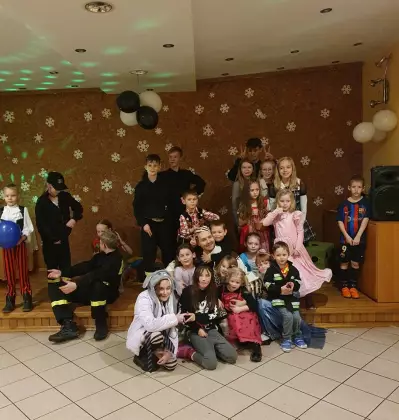 Dzieci stojące na balu karnawałowym.