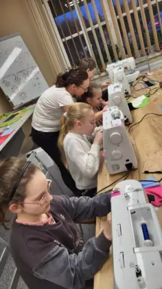 Uczestniczki zajęć szyją na maszynach poduszki.