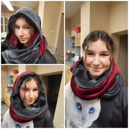 Dziewczyna prezentuje kominokaptur, który uszyła na zajęciach