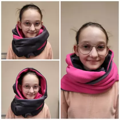 Dziewczyna prezentuje kominokaptur, który uszyła na zajęciach