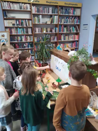 Przedszkolaki oglądają makietę dinozaurów.