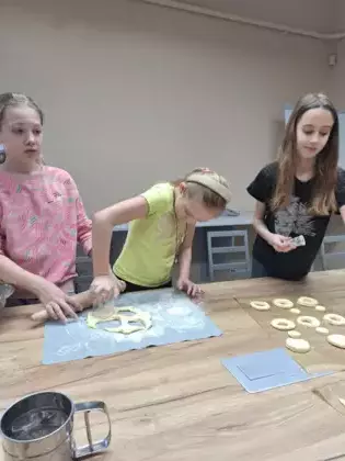 Dziewczyny formują z ciasta oponki.