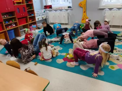 Kocia gimnastyka przedszkolaków na dywanie.