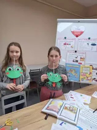 Uczestniczki zajęć prezentują prace plastyczną - żabę.