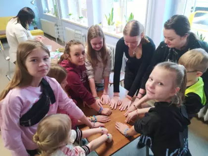 Uczestnicy warsztatów prezentują wykonaną biżuterię.