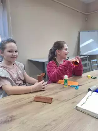 Dziewczyny oklejają papierowe rolki.