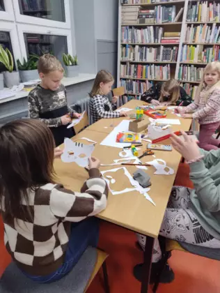 Dzieci wycinają i malują maski kota.