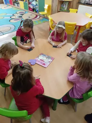 Przedszkolaki kolorują obrazki.