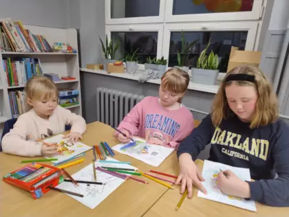 Trzy dziewczynki kolorują obrazki.