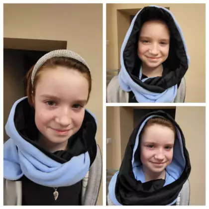 Dziewczyna prezentuje kominokaptur, który uszyła na zajęciach