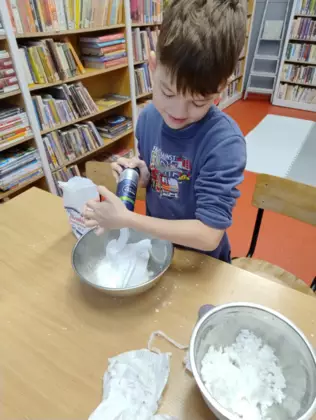 Chłopczyk wyciska piankę do golenia do miski.