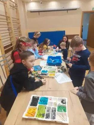 czestnicy warsztatów składają autka z klocków Lego.