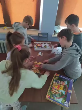 Dzieci układają puzzle Z Kubusia Puchatka.