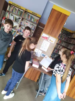 Uczniowie klasy trzeciej oglądają słowniki ortograficzne.