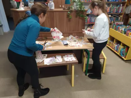 Dziewczyny wycinają elementy z kolorowych serwetek.