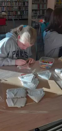 Dziewczyna maluje gipsową figurkę.