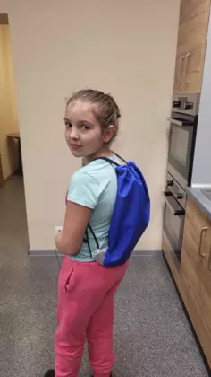 Uczestnik zajęć prezentuje na plecach swój niebieski workoplecak