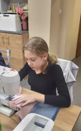 Dziewczynka szyje na maszynie piórnik.