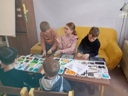 Dzieci budują pojazdy z kolcków LEGO.