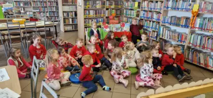 Dzieci słuchają bajki pt. Rower Walentynki czytanej przez panią bibliotekarkę.