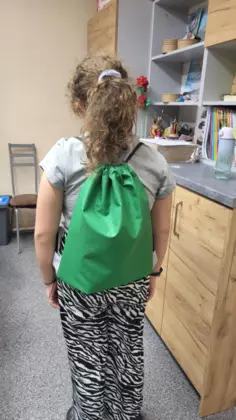 Uczestnik zajęć prezentuje na plecach swój zielony workoplecak