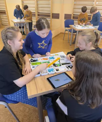 Uczestnicy budują z klocków lego samochodziki.