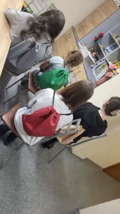 Grupa uczestników zajęć, prezentuje workoplecaki.