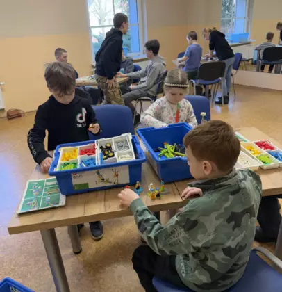 Uczestnicy budują z klocków lego samochodziki.