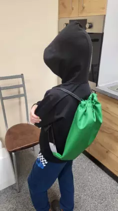 Uczestnik zajęć prezentuje na plecach swój zielony workoplecak