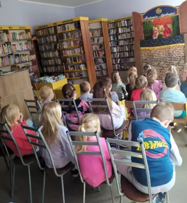 Dzieci z zaciekawieniem patrzą na lalkowy teatrzyk o Czerwonym Kapturku.