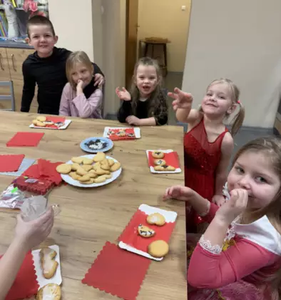 Dzieci lukrują już upieczone ciasteczka.