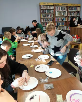 Uczestnicy robią bronsoletki na warsztatach tworzenia biżuterii.