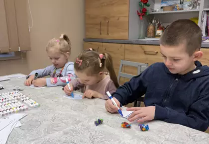 Dzieci malują paski na zebrze z papieru.