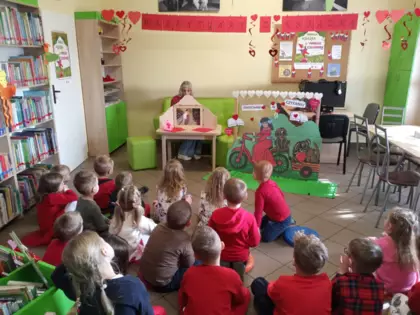 Dzieci słuchające bajkę zaprezentowaną w formie teatrzyku Kamishibai.