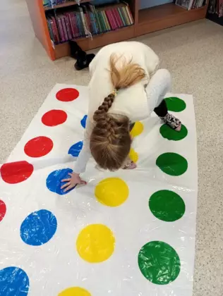 Dziewczynka na macie do Twistera.